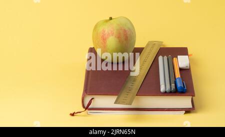 Work desk of a student, a schoolboy - educational supplies on a yellow background, a place for text Stock Photo