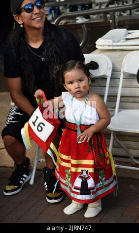 A Native American parent prepares his daughter to compete in the Native American Clothing Contest at the Santa Fe Indian Market in New Mexico. Stock Photo