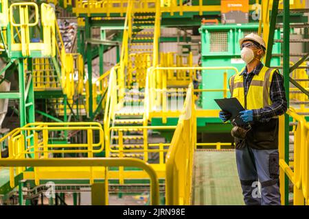 Caucasian City Trash Sorting Facility Worker in His 40s Wearing Safety Glasses and a Hardhat. Waste Management Industry. Stock Photo