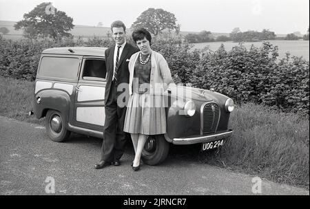 1950s, historical, a couple standing for a photo outside their small Austin A30 delivery van, parked on the grass verge in a country lane, England, UK. The Austin badge is on the front grill and the distinct Austin Flying A emblem on the bonnet, England, UK. Stock Photo