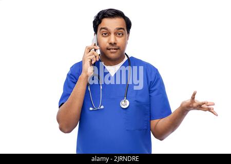indian doctor or male nurse calling on smartphone Stock Photo
