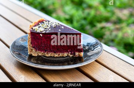 Blueberry or black currant raw cake piece close up on wooden table outside vegan food vegetarian dessert Stock Photo