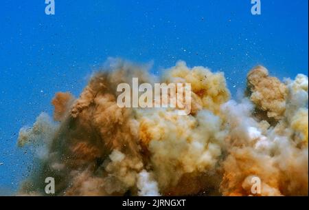 Dust clouds and debris after powerful dynamite blast on the mining site Stock Photo