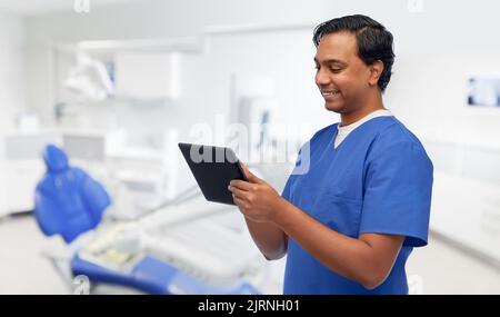 happy doctor or male dentist using tablet computer Stock Photo