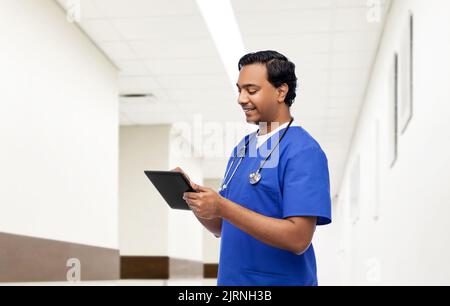 indian doctor or male nurse using tablet computer Stock Photo