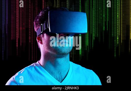 man in vr glasses in neon lights over binary code Stock Photo