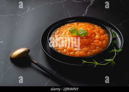 Pumpkin and carrot baby puree in dish isolated on black background Stock Photo