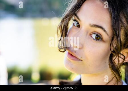 Close Up Portrait of a Young Woman Leaning on Tree with the Palace of Fine Arts in the Background Stock Photo