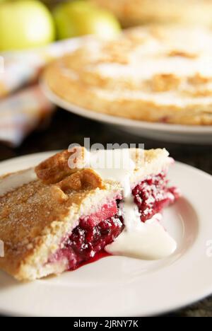 Homemade blackberry and apple pie. Made with homegrown apples and wild blackberries from England. Serving with fresh cream. Stock Photo
