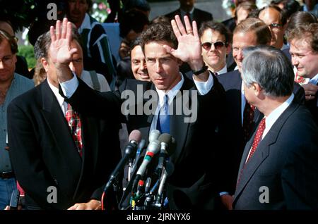 Mississippi Attorney General Mike Moore, center, and lead negotiator in the  lawsuit between the states and the tobacco industry holds his hands up to  calm the press as he announces a tentative
