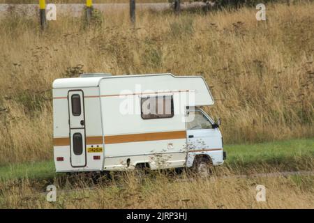 Vauxhall Bedford Rascal 1991 Nipper, 3 Berth, Overcab bed Campervan driving through parched summer countryside Stock Photo