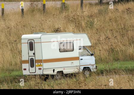 Vauxhall Bedford Rascal 1991 Nipper, 3 Berth, Overcab bed Campervan driving through parched summer countryside Stock Photo