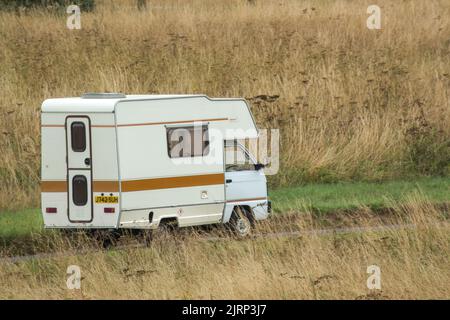 Vauxhall Bedford Rascal 1991 Nipper, 3 Berth, Overcab bed Campervan driving through parched summer countryside Stock Photo