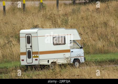 Vauxhall Bedford Rascal 1991 Nipper, 3 Berth, Overcab bed Campervan driving through parched summer countryside Stock Photo