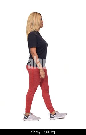 side view of a woman with sportswear walking  on white background Stock Photo