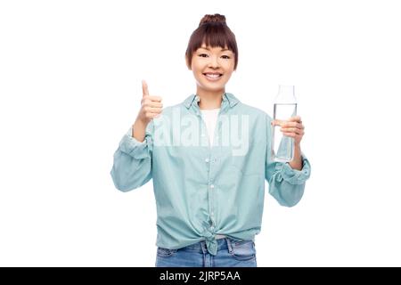 happy asian woman holding glass bottle with water Stock Photo
