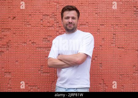 Young confident male model posing with crossed hands Stock Photo