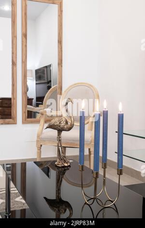 Living room corner with black glass end table with gold chandelier and wooden furniture Stock Photo