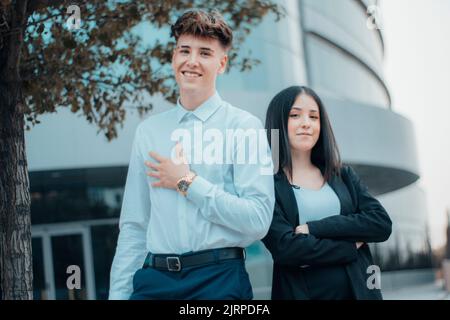 A young man and woman smiling and laughing happily in their break from business work Stock Photo