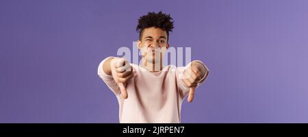 Close-up portrait of disappointed, unimpressed young hispanic man with dreads, grimacing skeptical, judging something bad, watched awful boring movie Stock Photo