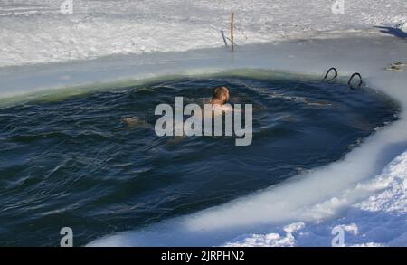 Ice pool swimming in frozen Ural river Stock Photo
