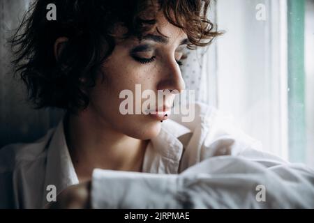 girl at the window in an old house Stock Photo