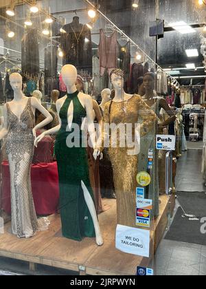 Evening dresses on display in a window in the Garment District on the west side of Manhattan, New York City. Stock Photo