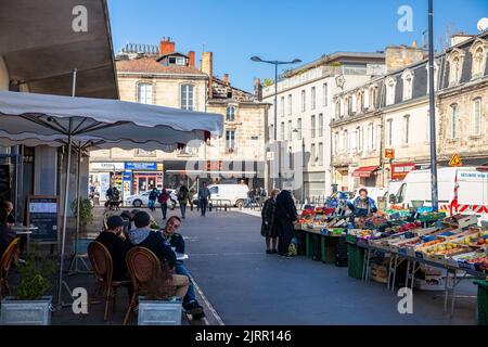 Picture of a stand of Marche des capucins market in Bordeaux, France,with a crowd of a french people, clients, buying fruits and vegetables. Stock Photo