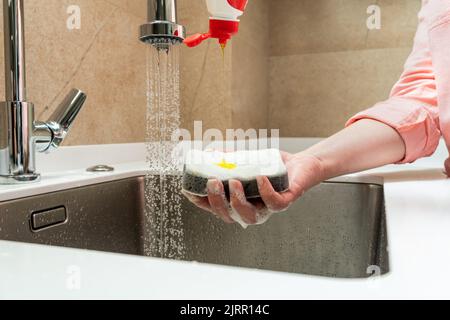 Dishwashing detergent dripping on the buzzer in hand Stock Photo