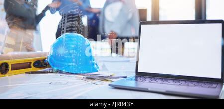 Mockup of architect laptop and planning blueprint, helmet and tools on desk overlay for future architecture building design. Double exposure engineer Stock Photo