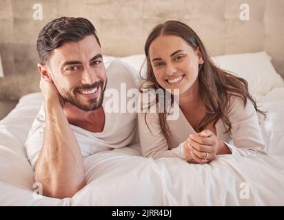 Love couple together in bedroom house, apartment or home to relax, smile and be happy. Portrait of romantic man and woman, young people and intimate Stock Photo
