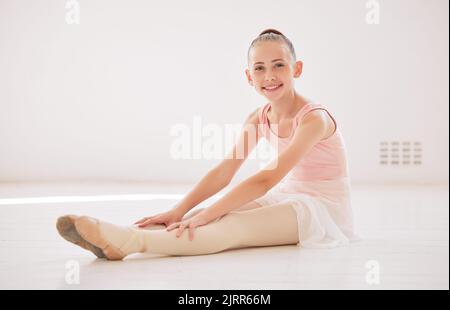 Wellness, fitness and ballet girl learning, workout and training in studio, dancer stretching before theatre event or sport exercise. Health Stock Photo