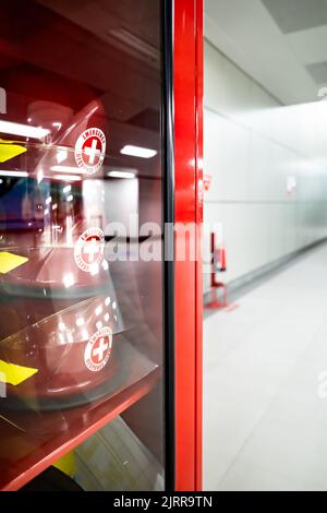 Safety equipment cabinet filled with helmets in public area building Stock Photo