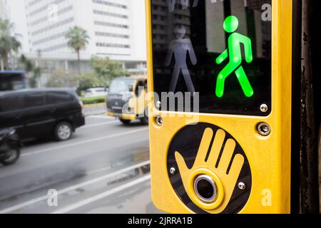 Walk signal sign located at pedestrian crosswalk area on a busy city street Stock Photo