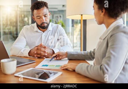 Accountant consulting an entrepreneur about company financial performance in an office using statistics. Finance advisor in a meeting having a Stock Photo
