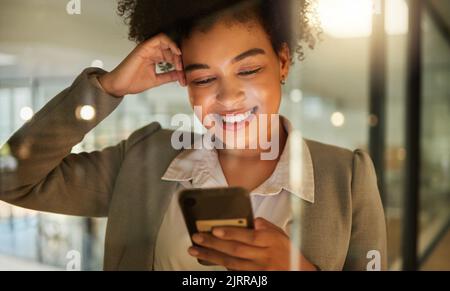 Business woman on a phone networking on social media, reading a blog or research in corporate office. Working lady browsing internet, company website Stock Photo