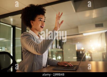 Surprised, shocked and excited business woman by a virtual or digital screen in an office while typing on a laptop. A female employee working late at Stock Photo