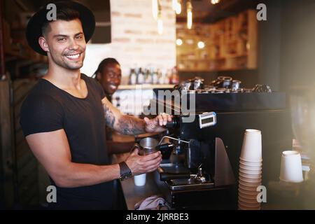 Havent had my coffee Then you havent had the best. a young man operating a coffee machine in a cafe. Stock Photo