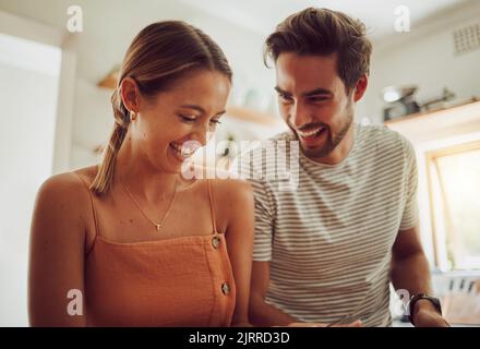 Happy laughing couple with smile bonding and having fun while having time together at home. Joke, in love and carefree couple talking and sharing a Stock Photo