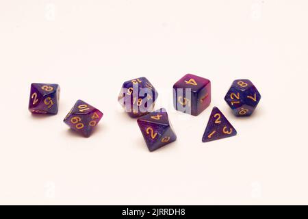 Seven purple multi-shaped fantasy table dice isolated on white background Stock Photo
