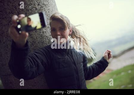 Posing for a sporty selfie. a sporty young woman taking a selfie while out for a run in the city. Stock Photo