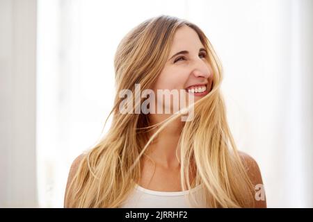 Hair so luscious you cant help but whip it. a beautiful young woman flipping her hair in the bathroom at home. Stock Photo