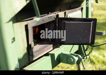 Wood burning stove. Door of outdoor stove is used as field kitchen. Steel object for military purposes. Mobile kitchen. Stock Photo
