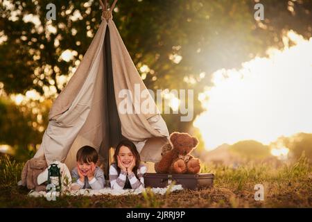 Well let you come in if you know the password. Portrait of two cute little siblings playing together in a teepee outside. Stock Photo