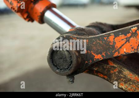 Hydraulic holder. Tractor parts. Heavy machinery up close. Orange equipment. Hard grip. Stock Photo