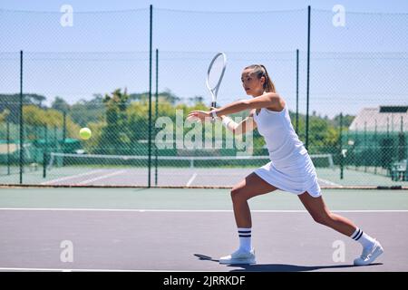 Fitness, exercise and sport with training tennis player playing competitive match at a tennis court. Woman athlete practicing cardio in a game. Young Stock Photo