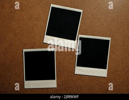 Three blank photo frames on brown table Stock Photo