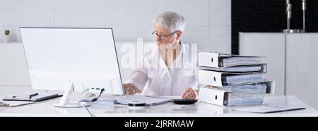 Accountant With Folders Paper Stack Doing Invoice Audit Stock Photo