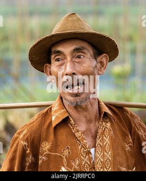 Indonesia, June 13 2022 - Old man with missing teeth smailes when talking. Stock Photo