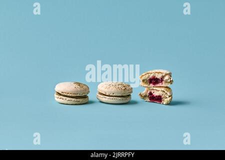 White macarons cake with colorful powder, top view, flat lay, sweet macaroon on blue background. Stock Photo